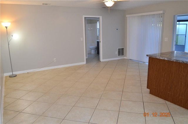 tiled empty room with ceiling fan