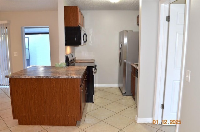 kitchen featuring stainless steel appliances, a textured ceiling, and light tile patterned flooring