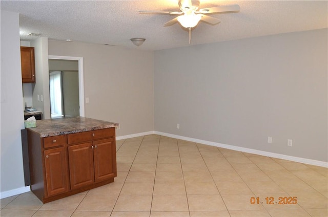 kitchen featuring light tile patterned flooring, ceiling fan, and a textured ceiling