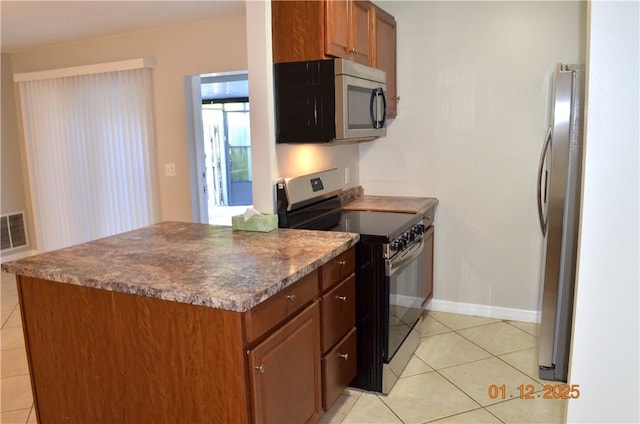 kitchen with light tile patterned flooring and appliances with stainless steel finishes