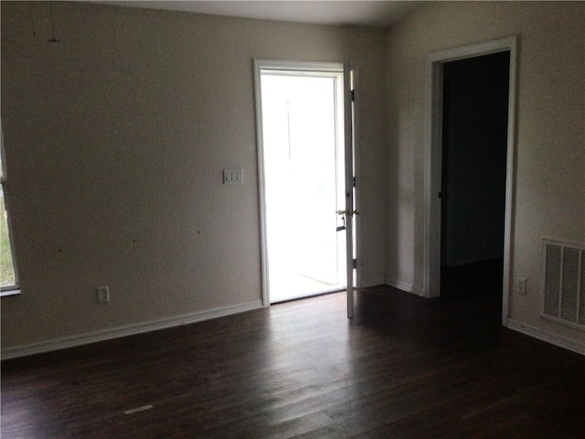 unfurnished room featuring a healthy amount of sunlight and dark hardwood / wood-style flooring