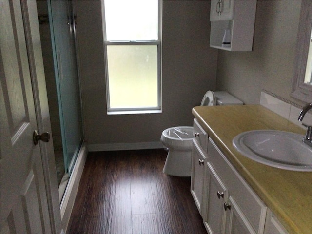 bathroom with vanity, hardwood / wood-style floors, an enclosed shower, and toilet