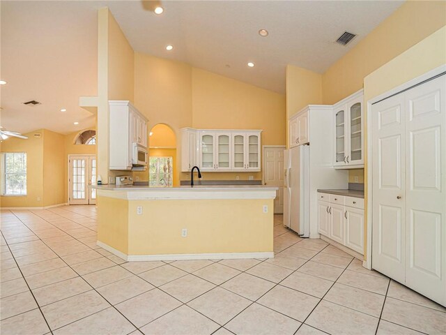 kitchen featuring white cabinets, ceiling fan, white appliances, and light tile patterned floors