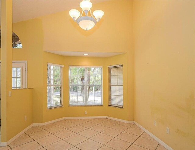 spare room with light tile patterned floors and a chandelier