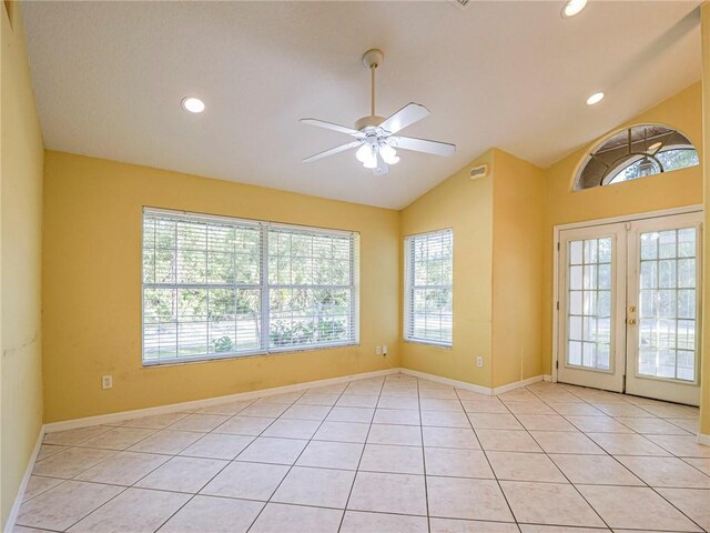 tiled spare room featuring french doors, vaulted ceiling, and plenty of natural light