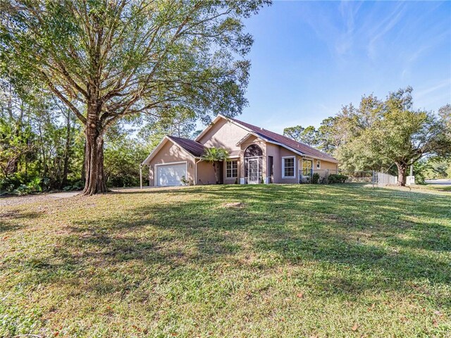 view of front of property with a front yard and a garage