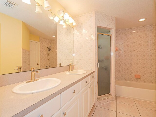 bathroom with tile patterned floors, vanity, and shower with separate bathtub