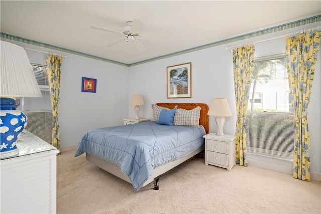 carpeted bedroom with ceiling fan and ornamental molding