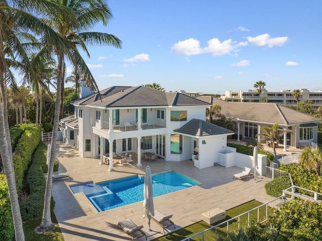 rear view of house with a balcony, a patio area, and a fenced in pool