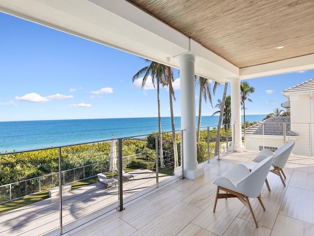 balcony featuring a water view and a view of the beach