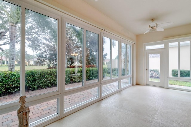 unfurnished sunroom featuring ceiling fan