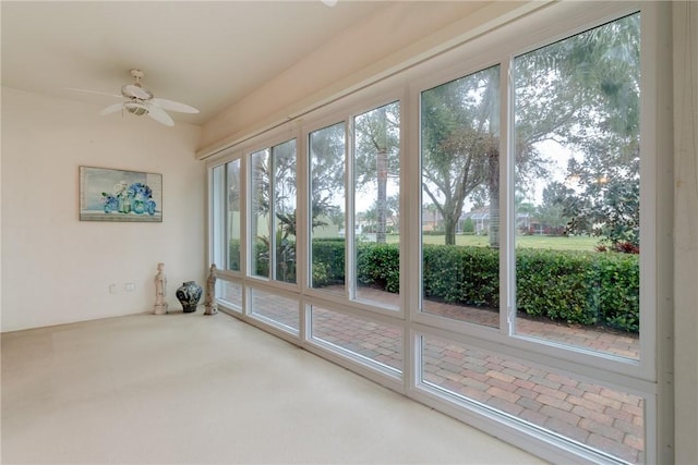 unfurnished sunroom featuring ceiling fan