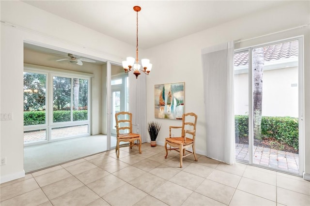 sitting room with ceiling fan with notable chandelier and light tile patterned floors