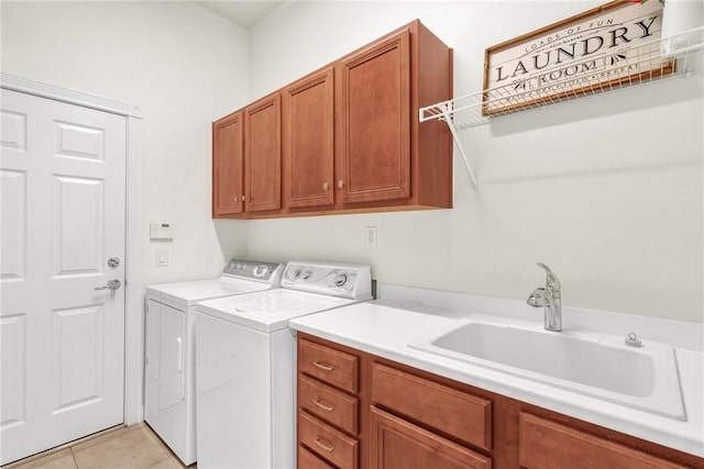 laundry area featuring light tile patterned flooring, cabinets, sink, and washing machine and clothes dryer