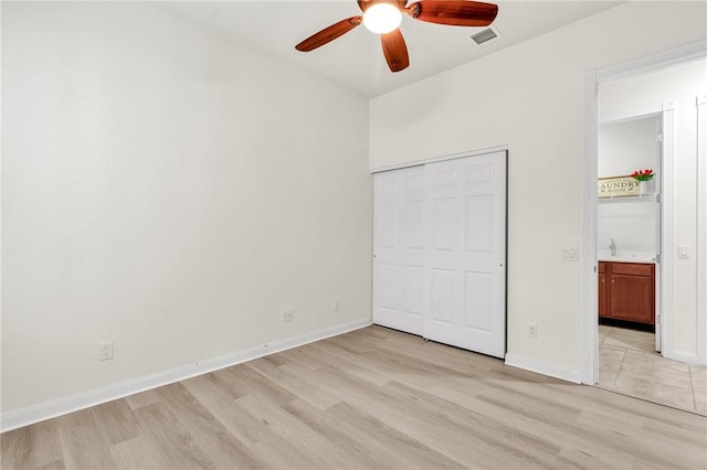 unfurnished bedroom featuring light wood-type flooring, a closet, and ceiling fan