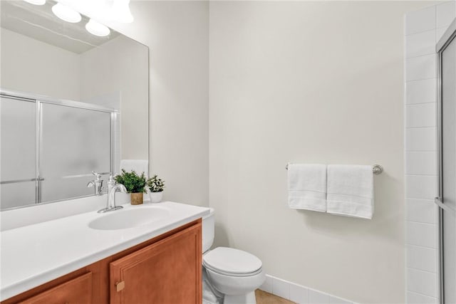 bathroom featuring toilet, walk in shower, and vanity