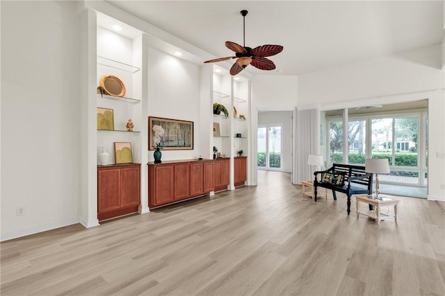 miscellaneous room with built in shelves, ceiling fan, and light hardwood / wood-style floors