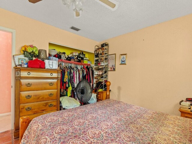 663 20th Pl SW, Vero Beach, FL 32962 - tiled bedroom with a closet, ceiling fan, and a textured ceiling