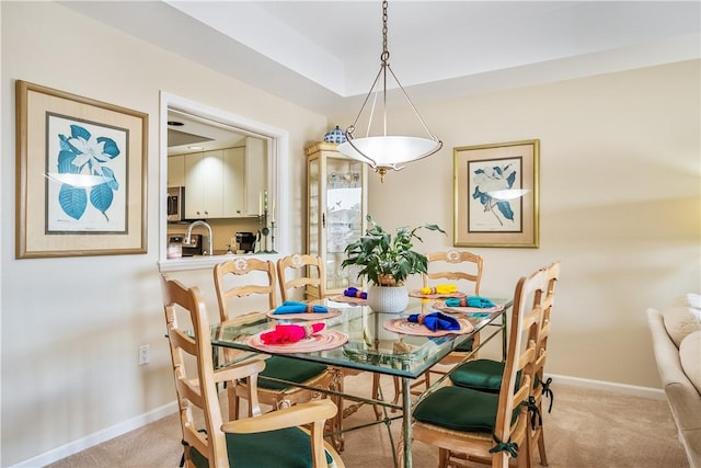 dining room featuring light carpet and baseboards