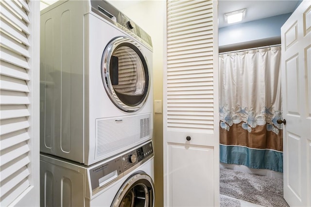 clothes washing area with stacked washer / dryer and laundry area