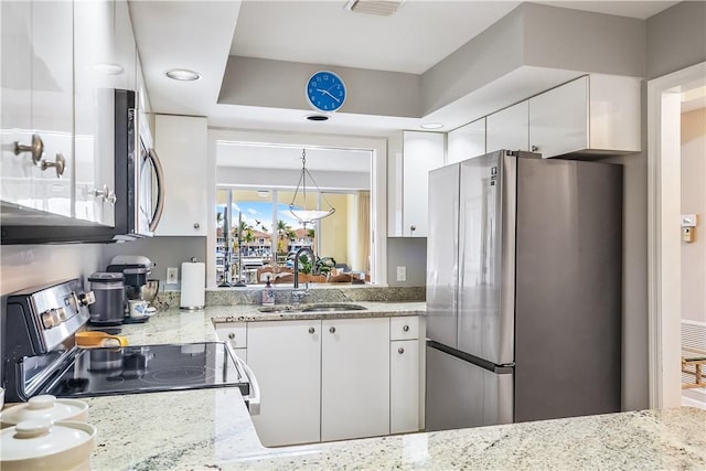 kitchen featuring a sink, visible vents, white cabinets, appliances with stainless steel finishes, and light stone countertops