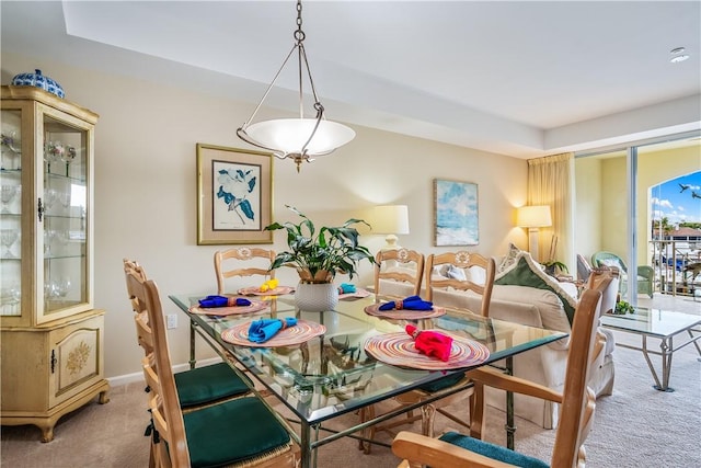 carpeted dining area featuring baseboards