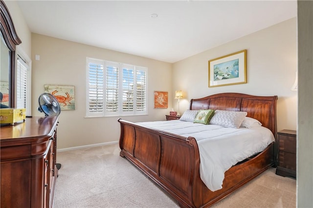 bedroom with light carpet and baseboards