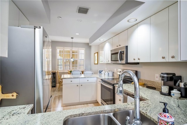 kitchen with visible vents, white cabinets, light stone counters, a peninsula, and stainless steel appliances