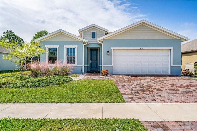 ranch-style home featuring a garage, stucco siding, decorative driveway, and a front yard