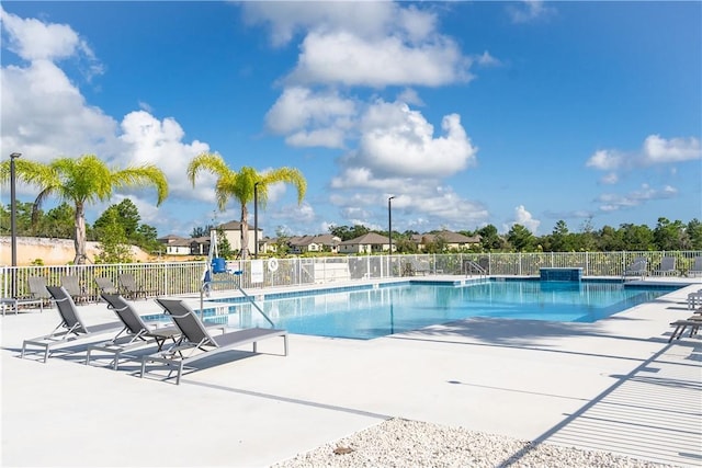 community pool featuring a patio area and fence