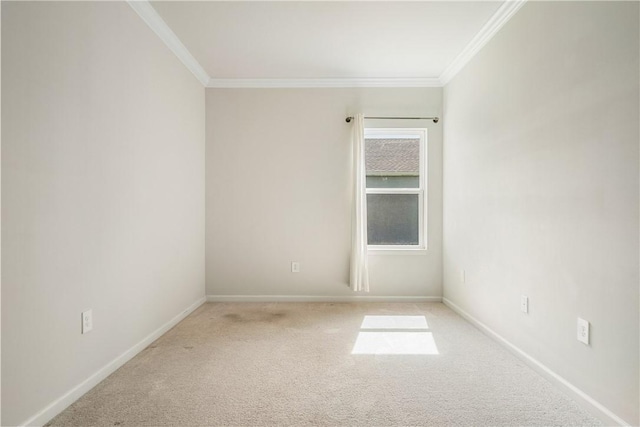 carpeted empty room featuring crown molding and baseboards