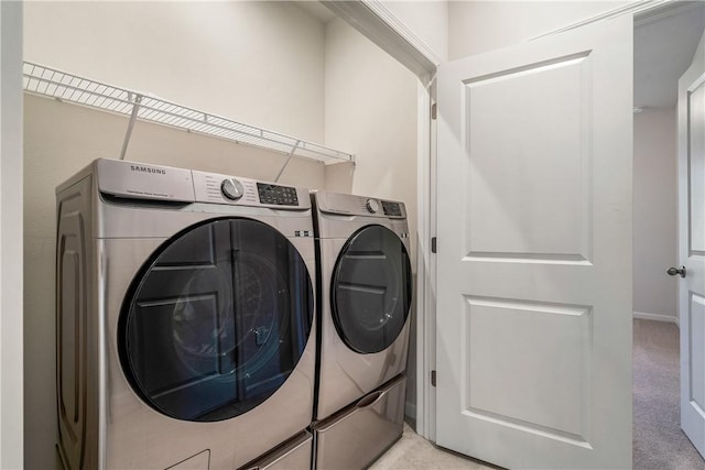 clothes washing area with independent washer and dryer and light carpet