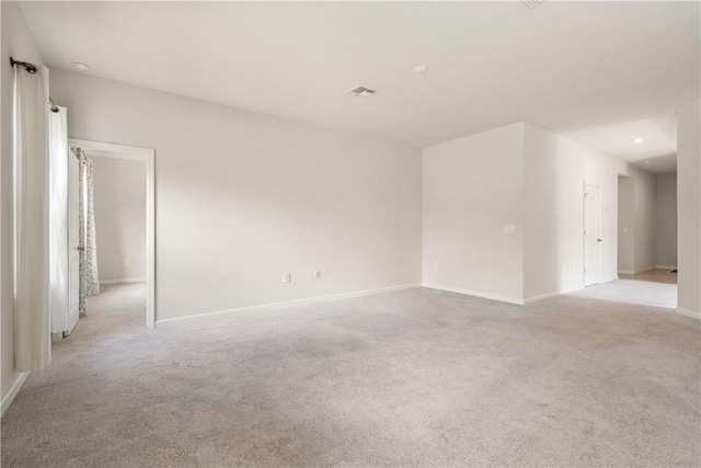 unfurnished room featuring visible vents, light carpet, and baseboards