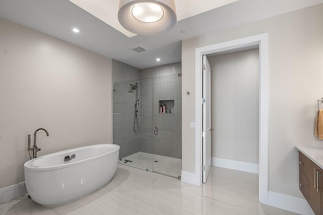 bathroom with vanity and shower with separate bathtub