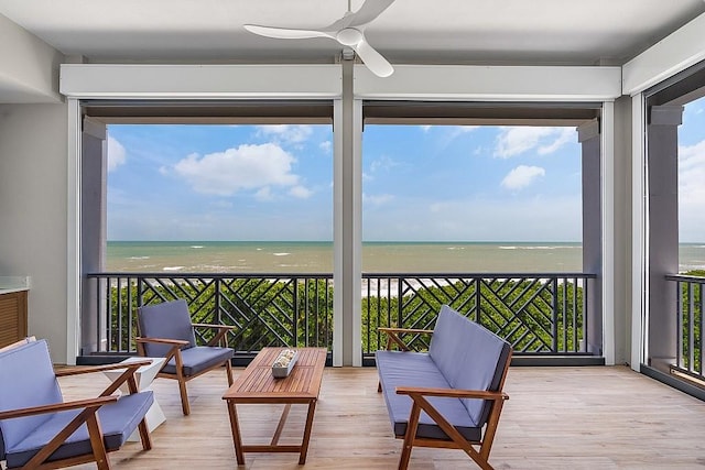 sunroom / solarium featuring a water view, plenty of natural light, and a beach view