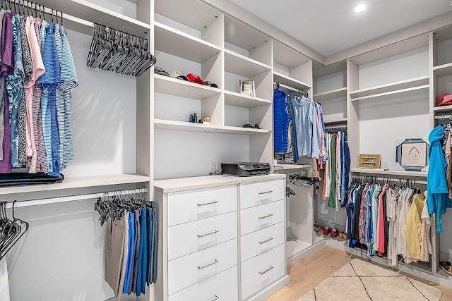 walk in closet with light hardwood / wood-style flooring