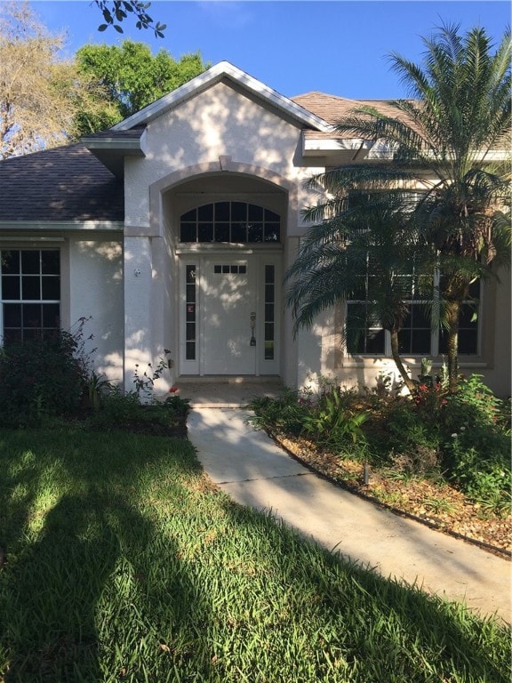 doorway to property featuring a lawn