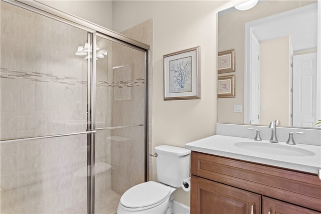 bathroom featuring toilet, an enclosed shower, and vanity