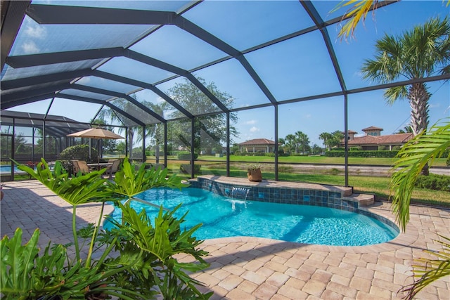 view of pool with glass enclosure, a patio area, and pool water feature