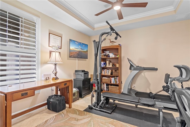 workout room featuring ceiling fan, crown molding, and a tray ceiling