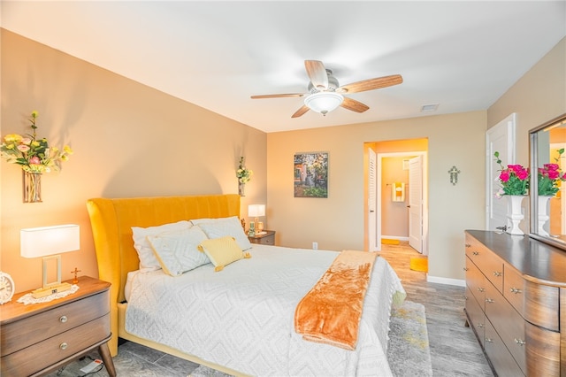 bedroom featuring ensuite bath, ceiling fan, and hardwood / wood-style floors