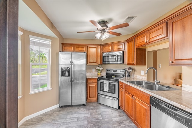 kitchen with wood-type flooring, stainless steel appliances, ceiling fan, and sink