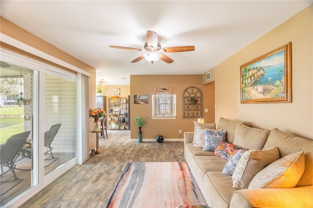 living room with ceiling fan, wood-type flooring, and a wealth of natural light