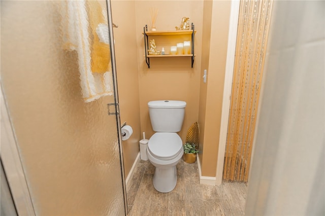 bathroom featuring hardwood / wood-style flooring, toilet, and walk in shower