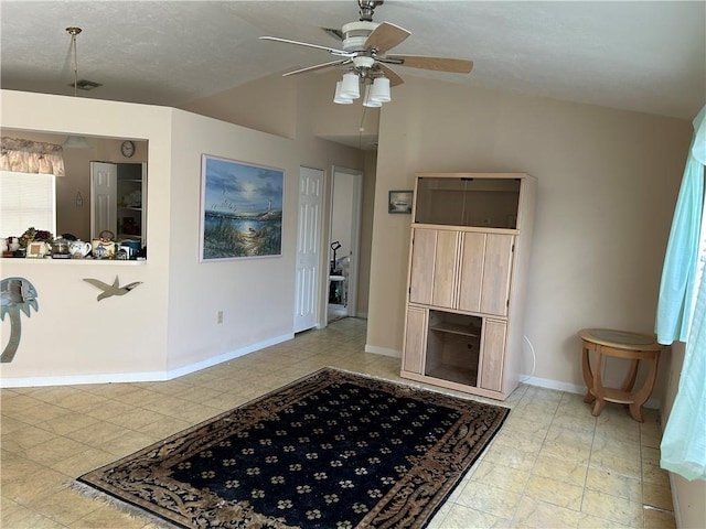 living room with lofted ceiling, ceiling fan, and baseboards