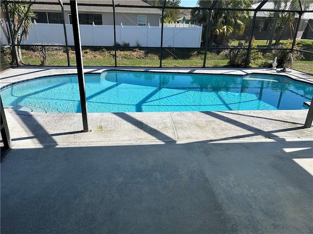 view of swimming pool featuring a fenced in pool, glass enclosure, fence, and a patio