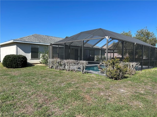 back of property featuring an outdoor pool, a lanai, and a lawn