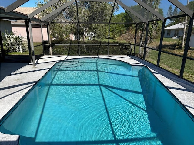 outdoor pool featuring glass enclosure and a patio area