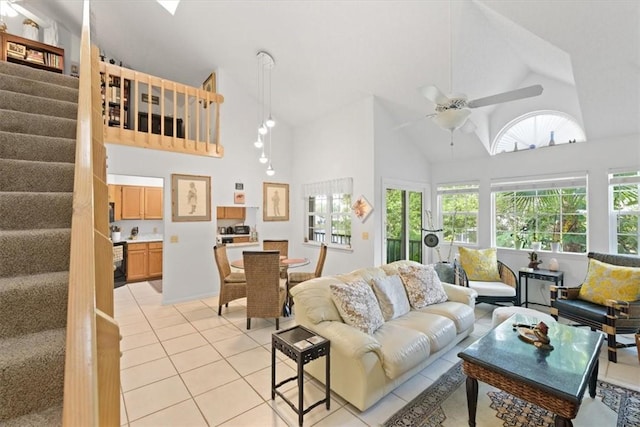 tiled living room with ceiling fan and high vaulted ceiling