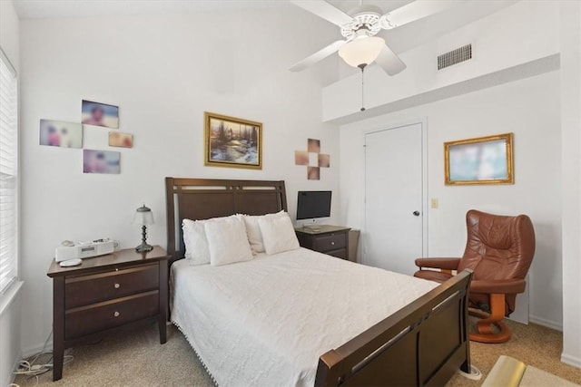 bedroom featuring multiple windows, ceiling fan, and light colored carpet